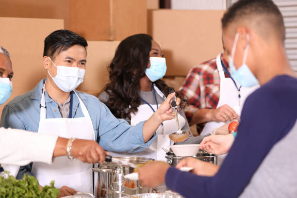 istock Multi-ethnic group of volunteers work at soup kitchen. 1283591267