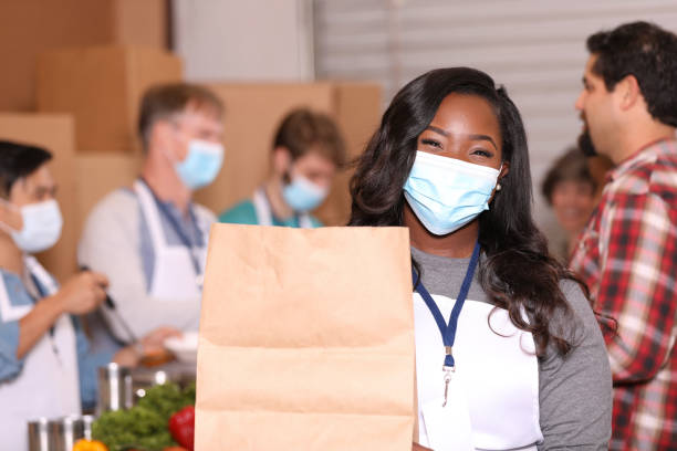 istock Multi-ethnic group of volunteers work at soup kitchen. 1283591294