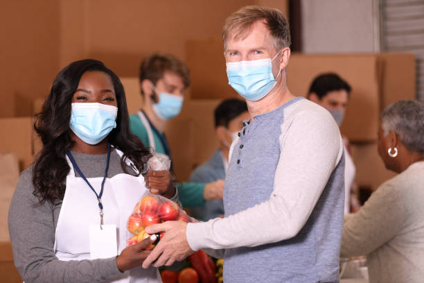 istock Multi-ethnic group of volunteers work at soup kitchen. 1283591321