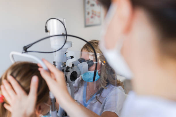 istock Ophthalmologist inspecting patient's eye sight via phoropter 1283594389