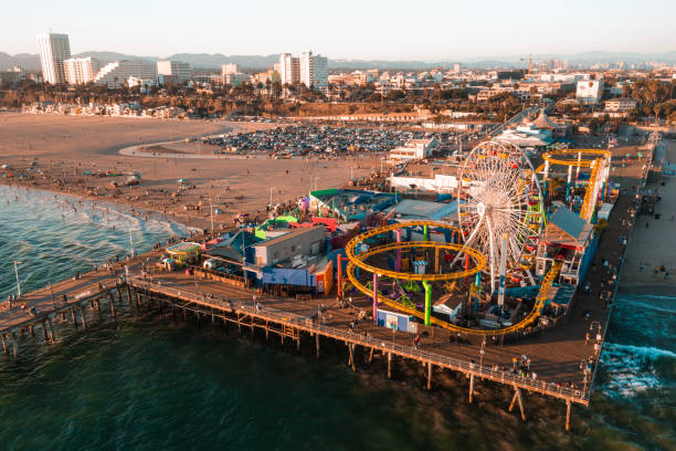 muelle de santa mónica al atardecer con luces reflejadas en el océano pacífico - santa monica pier fotos fotografías e imágenes de stock