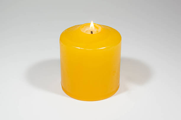 istock Burning yellow candle on gray white background 1283595184