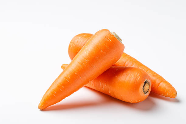 tre carote su sfondo bianco - carrot foto e immagini stock