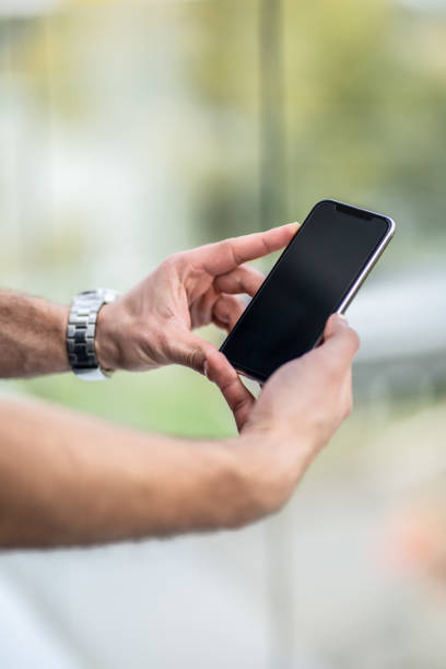 Businessman hand holding cell phone - close up