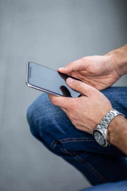 istock Businessman hand holding cell phone against white background - close up - horizontal vertical 1283597728