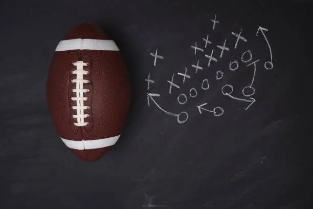 American College Football and play diagram on a chalkboard. Top view with copy space.