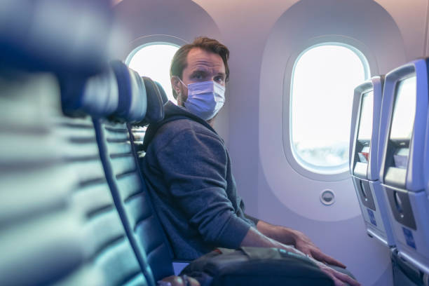 istock Man wearing protective face mask traveling on empty airplane 1283600066