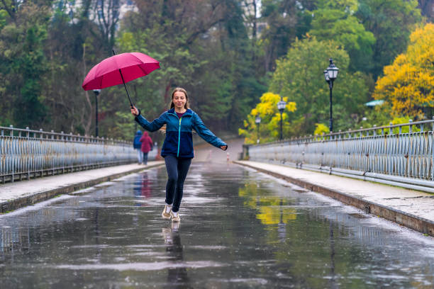 istock Woman withumbrella having fun in rainy day 1283600492