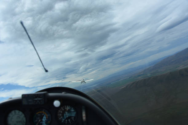 Full Frame View From a Glider Tethered to a Pilot Plane A full frame panoramic view from inside a sailplane capturing the towplane in front, prior to release over Omarama on the South island of New Zealand. Of course there is window glare, motion blur, and the horizon is tilted. omarama stock pictures, royalty-free photos & images