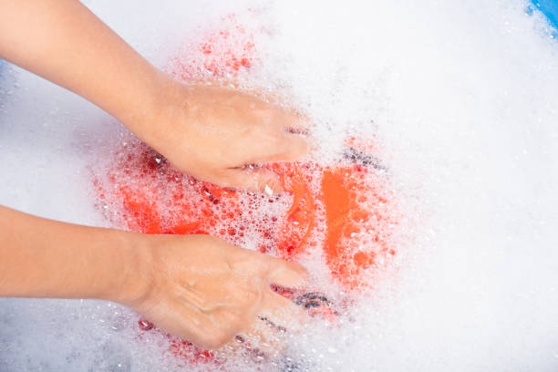 istock Woman use hands washing color clothes in basin 1283602344