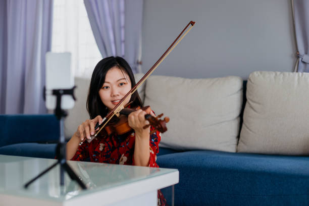 istock An Asian Chinese woman teaching violin class online using live streaming with smart phone 1283602490