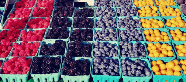strawberries, blueberries, blackberries on retail display in farmer's market - market fruit strawberry farmers market imagens e fotografias de stock