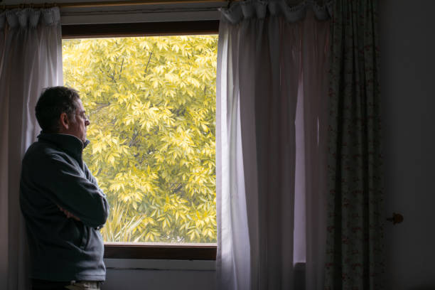 adult man looking out window