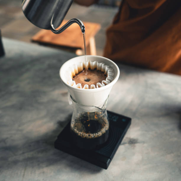 istock Drip coffee, barista pouring water on coffee ground with filter at home 1283616572