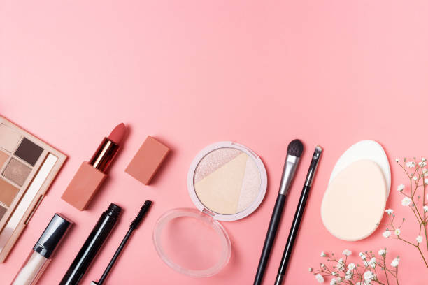 istock Lipstick, eye shadow and sponge on pink background, copy space. 1283620251