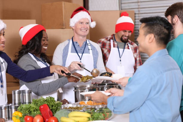 istock Multi-ethnic group of volunteers work at soup kitchen at Christmas. 1283625167