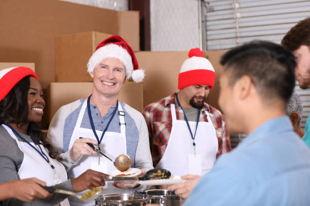 istock Multi-ethnic group of volunteers work at soup kitchen at Christmas. 1283625232