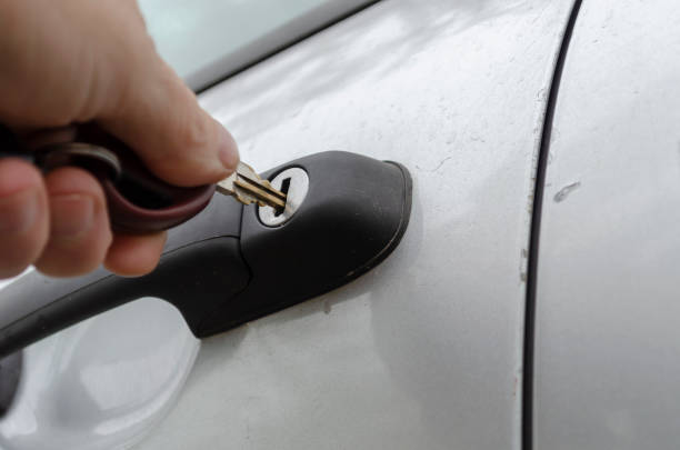 a mão do homem insere a chave na fechadura da porta do carro. - car car door car key door - fotografias e filmes do acervo