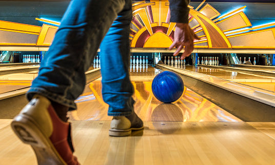 Close-up of a man bowling in a vintage bowling alley