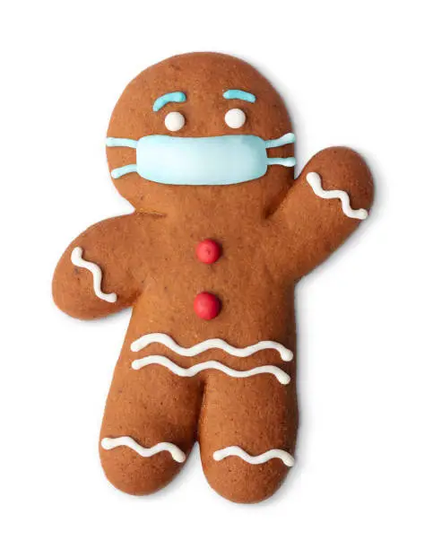 Classic gingerbread cookie man with medical mask isolated on white. Covid joke. Christmas objects. Coronavirus christmas decor.