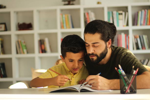 istock Father Helping Son With Homework At Home. 1283666444