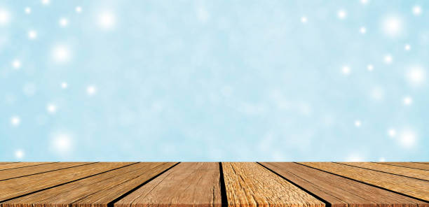 istock abstract blur soft focus bokeh bulbs light in blue color background with snowing glitter and wood table perspective for show,promote and advertise product and content in merry christmas and happy new year season concept 1283666760