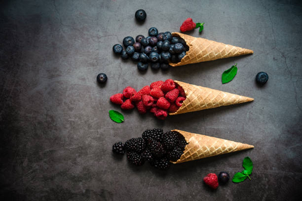 istock Fresh berries in waffle cone on dark stone background 1283666995