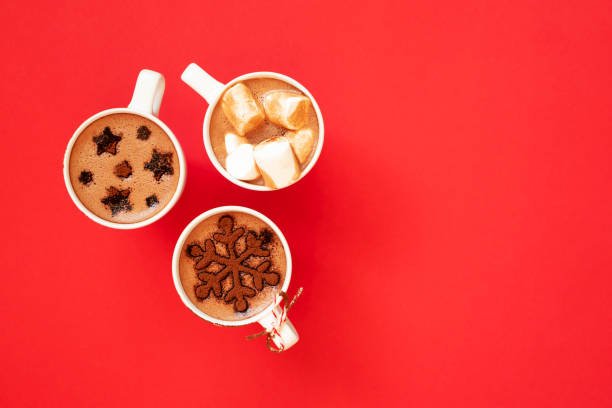 istock Hot chocolate with marshmallows and cocoa powder decor in white cups on red background 1283667341