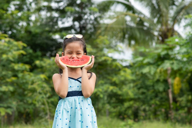 istock Asian girl standing and hold watermelon 1283668846