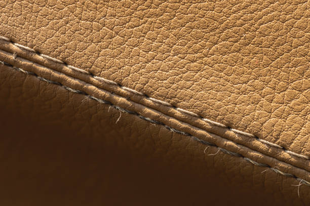 istock Artificial leather car upholstery, color beige, close-up stitching in macro mode 1283669506