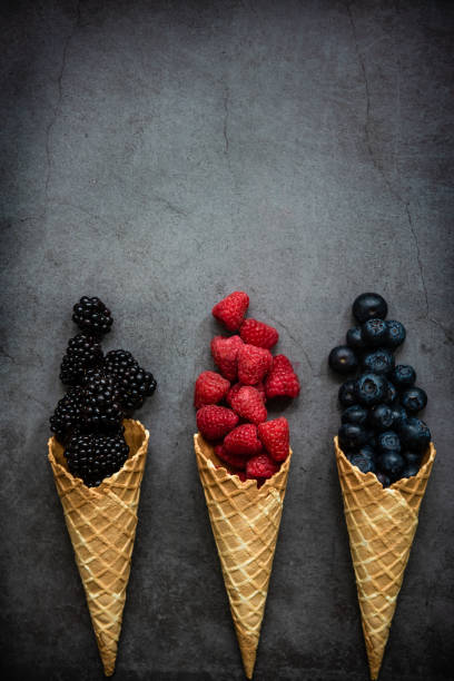 istock Fresh berries in waffle cones on dark stone background 1283670342