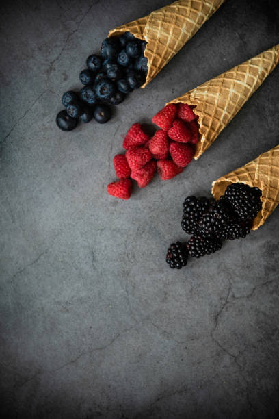 istock Fresh berries in waffle cones on dark stone background 1283671157