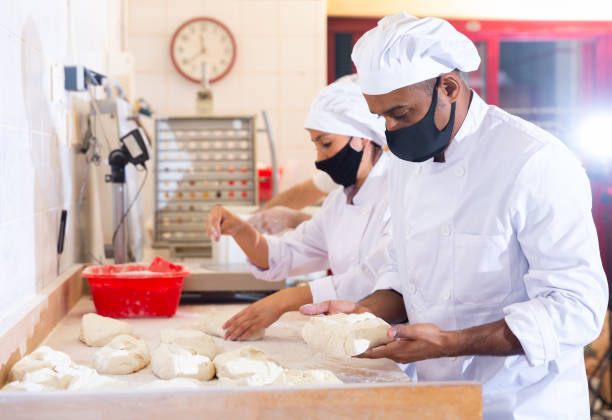 istock Latin american baker forming bread loaves from raw dough 1283671403