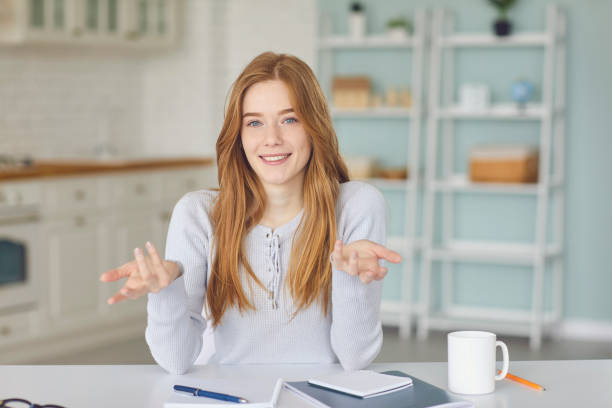 istock Portrait of young woman communicating online, watching video tutorial or participating in webinar at her kitchen 1283671444
