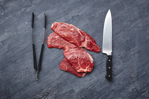 istock Raw meat beef steak on black top view. 1283671659