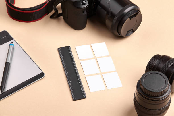 cámara con lentes, tableta de dibujo gráfico y lápiz óptico, regla negra y seis pequeñas hojas de papel sobre fondo rosa. de cerca, copie el espacio - office tool flash fotografías e imágenes de stock