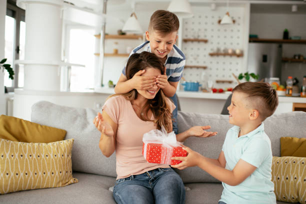 istock Two young sons are giving their mother a gift. 1283672111