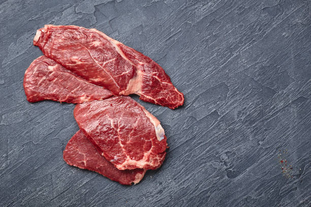 istock Raw meat beef steak on black top view. 1283672290