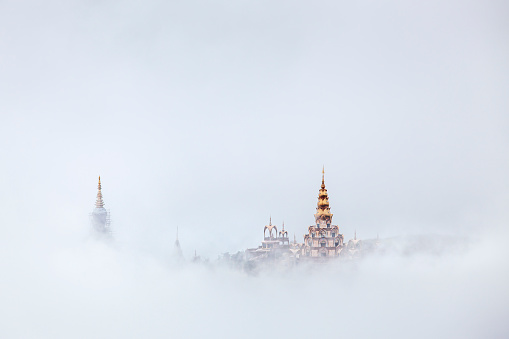 Morning view of the white big buddha in the mist  at Wat Prathat Phasornkaew, Khao Kho, Phetchabun, Thailand