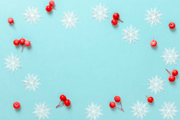 istock Christmas pattern. White snowflakes, red berry in Christmas composition on pastel blue background for greeting card. Winter festive composition with copy space. 1283673096
