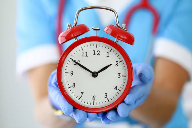 Doctor's hands in gloves hold red alarm clock. Doctor's hands in gloves hold red alarm clock. Definition of illness during and diagnosis of illness during concept time danger stock pictures, royalty-free photos & images