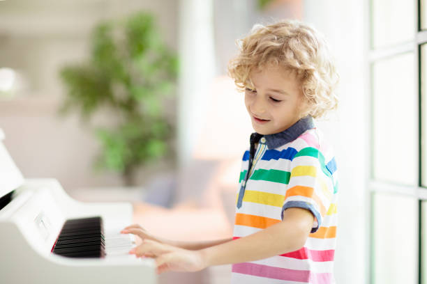 istock Child playing piano. Kids play music. 1283675929