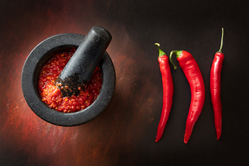 Spices: chili powder and turmeric on spoons. Rosemary and star anise on white