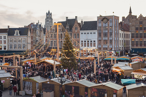 Bruges, Belgium - November 30, 2019 - Traditional Christmas market with stalls, decorated Christmas tree at the Bruges main square