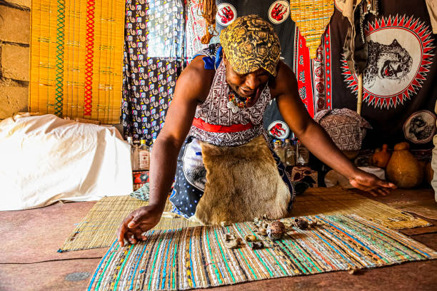 African Male Traditional Healer known as a Sangoma or witch-doctor performing a spiritual reading Sabi Sabi, South Africa - May 5, 2012: African Male Traditional Healer known as a Sangoma or witch-doctor performing a spiritual reading sangoma photos stock pictures, royalty-free photos & images