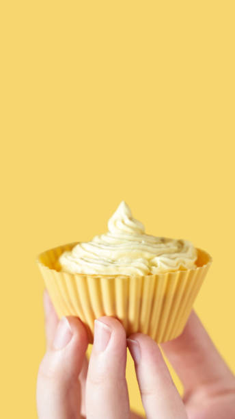 istock Yellow monochrome bakery. Sustainable cupcake cup. Hold in hand 1283677053