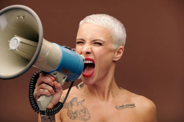 istock Furious and annoyed blond manlike female shouting loudly in megaphone 1283678016