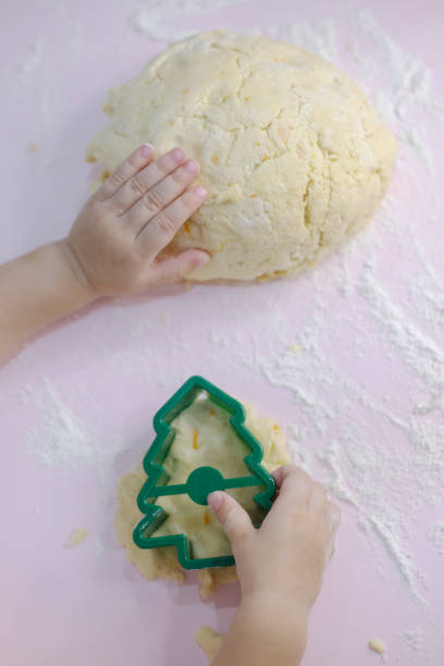 the child's hands with the dough and cookie cutter - pastry cutter family holiday child imagens e fotografias de stock