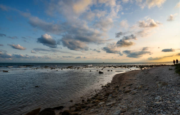 Couple at the seashore at sunset. Black Sea shore near Balchik's Tuzla place. Bulgaria, Europe.