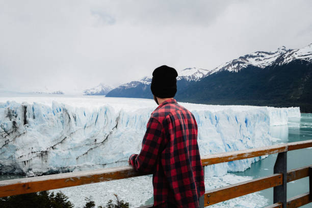 istock A young man is looking at Perito Moreno Glacier view from behind 1283681113